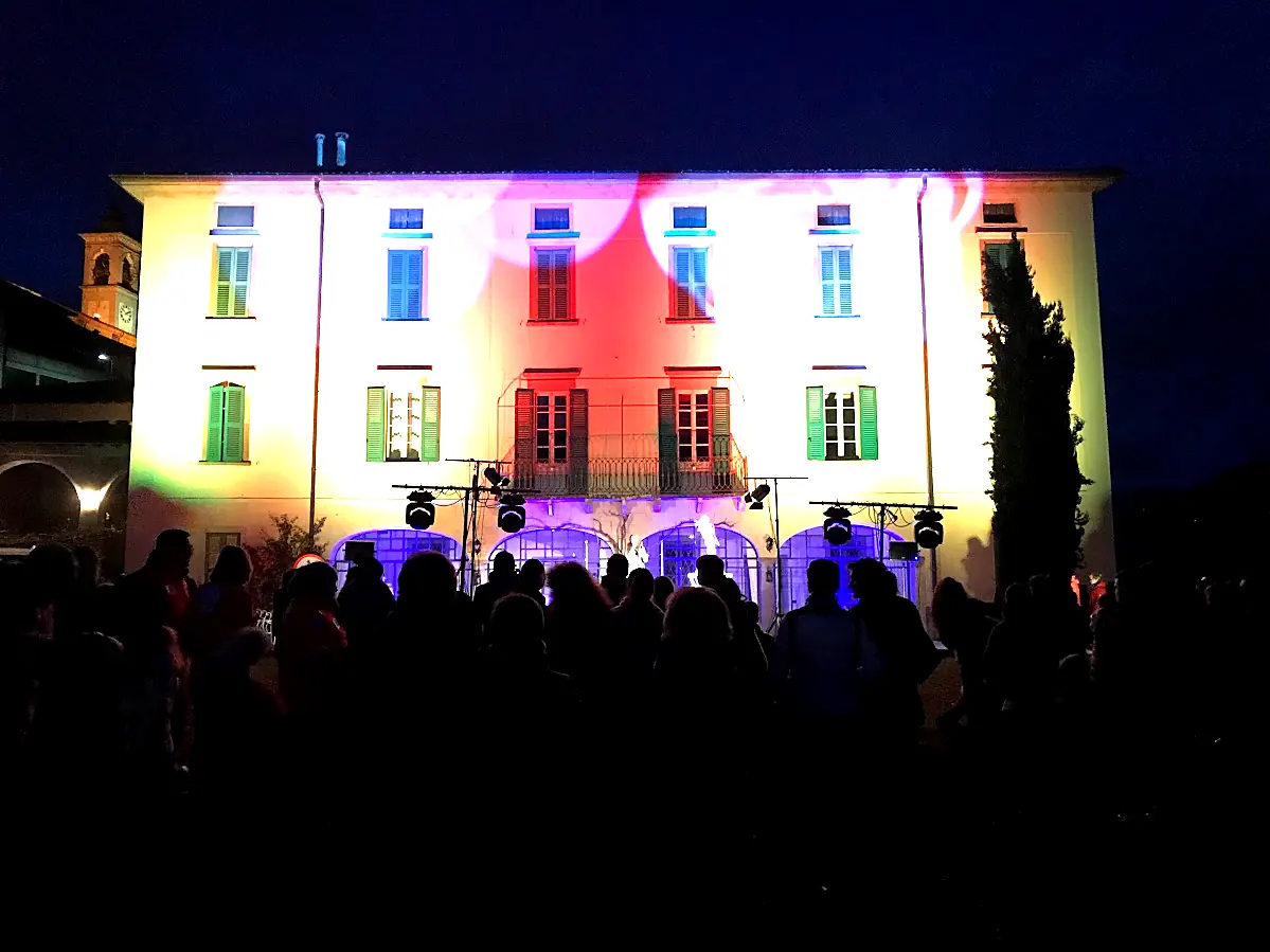 La facciata della dimora illuminata durante una festa serale