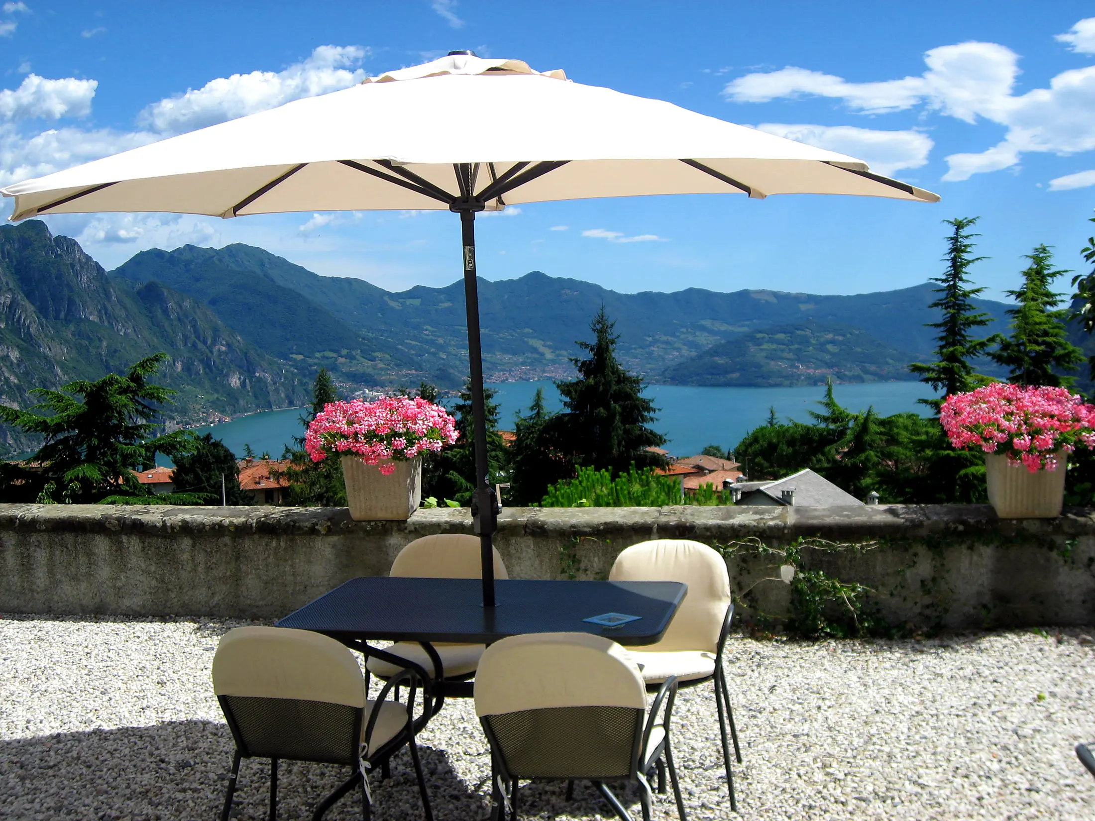 Il solarium con l'ombrellone, i fiori e il lago d'Iseo sullo sfondo