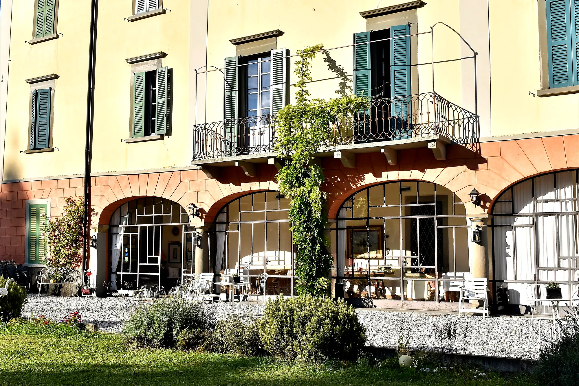 La veranda ad archi alla base della dimora, con la vite e i fiori